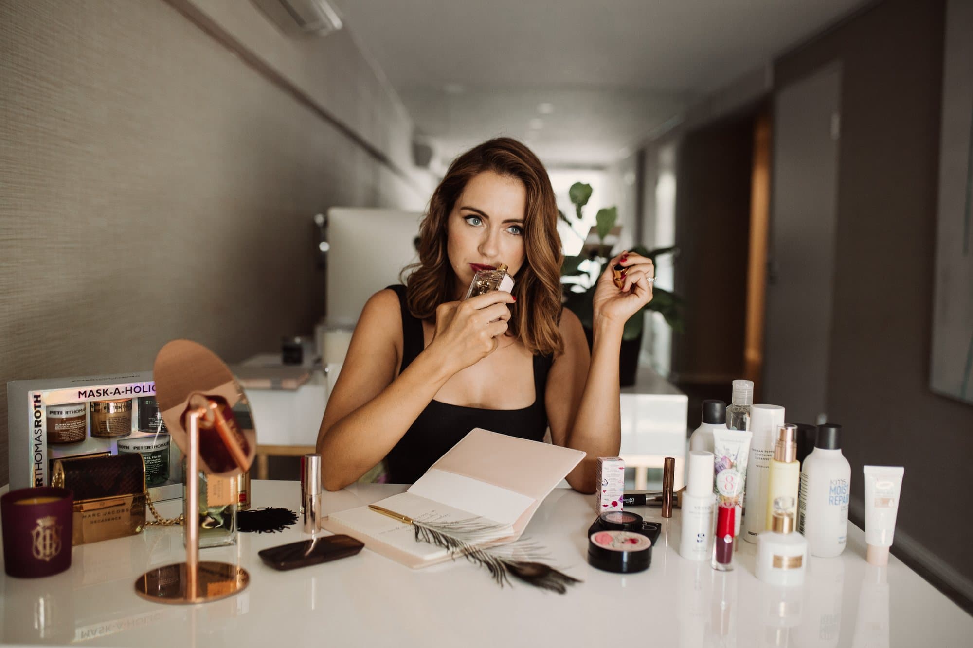 A vanity desk with a notebook, pen and beauty products — where the product testing behind the copy happens